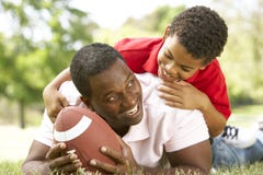 Père et fils en stationnement avec le football américain Père et fils en stationnement avec le football américain