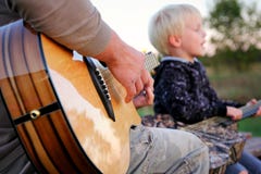 Père et guitare jouante extérieure et chant de fils photos libres de droits Père et guitare jouante extérieure et chant de fils photos libres de droits
