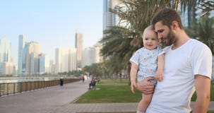 Père jouant avec des fils pendant l'été dans une ville moderne le tenant et étreignant la position dans un T-shirt blanc et des s banque de vidéos Père jouant avec des fils pendant l'été dans une ville moderne le tenant et étreignant la position dans un T-shirt blanc et des s banque de vidéos