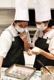 Pékin Chine - 10 juin 2018 : Deux chefs présentent la pâte de biscuit sur un plateau de cuisson de fer image libre de droits Pékin Chine - 10 juin 2018 : Deux chefs présentent la pâte de biscuit sur un plateau de cuisson de fer image libre de droits