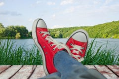 Pés em sapatas do esporte no feriado, com uma ideia da natureza imagem de stock Pés em sapatas do esporte no feriado, com uma ideia da natureza imagem de stock