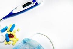 Píldoras amarillas, azules, rojas y el termómetro y la máscara, medicina aislada en el fondo blanco fotos de archivo Píldoras amarillas, azules, rojas y el termómetro y la máscara, medicina aislada en el fondo blanco fotos de archivo