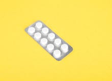 Píldoras en un paquete gris Un solo paquete de las píldoras y de las tabletas blancas Drogas medicinales en un fondo amarillo col imagen de archivo Píldoras en un paquete gris Un solo paquete de las píldoras y de las tabletas blancas Drogas medicinales en un fondo amarillo col imagen de archivo