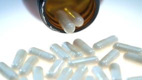 Píldoras herbarias en la tabla blanca Producción de Pharmatheutical Cápsula de la hierba en tubo metrajes Píldoras herbarias en la tabla blanca Producción de Pharmatheutical Cápsula de la hierba en tubo metrajes