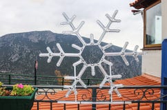 Płatek śniegu Bożenarodzeniowa dekoracja na ogrodzeniu w Delphi Grecja dachówkowym dachem, balkonową przegapia głęboką dolina i g obraz stock Płatek śniegu Bożenarodzeniowa dekoracja na ogrodzeniu w Delphi Grecja dachówkowym dachem, balkonową przegapia głęboką dolina i g obraz stock