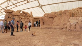 Qrendi, Мальта - посетители 10-ое марта 2019 исследуя висок Mnajdra доисторический во время дня открытых дверей организованного н Qrendi, Мальта - посетители 10-ое марта 2019 исследуя висок Mnajdra доисторический во время дня открытых дверей организованного н