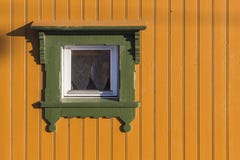 Quadratisches Fenster im hellen Gelb malte Bauholzwand mit grünem Franc Lizenzfreies Stockbild Quadratisches Fenster im hellen Gelb malte Bauholzwand mit grünem Franc Lizenzfreies Stockbild