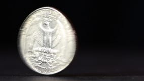 A quarter USD coin spinning on table
