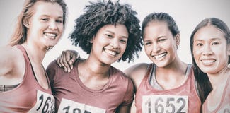 Quatre coureurs de sourire soutenant le marathon de cancer du sein photographie stock libre de droits Quatre coureurs de sourire soutenant le marathon de cancer du sein photographie stock libre de droits