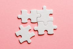 Quatre détails blancs de puzzle sur un fond rose image stock Quatre détails blancs de puzzle sur un fond rose image stock