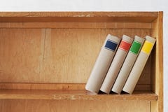 Quatre nouveaux livres sur une étagère en bois photo libre de droits Quatre nouveaux livres sur une étagère en bois photo libre de droits
