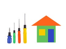 Quatre tournevis de différentes tailles avec des poignées bleues, vertes, de rouge et de jaune et une maison de bande dessinée de photographie stock Quatre tournevis de différentes tailles avec des poignées bleues, vertes, de rouge et de jaune et une maison de bande dessinée de photographie stock