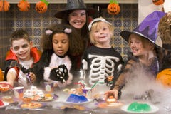 Quatro amigos novos e uma mulher em Halloween imagem de stock Quatro amigos novos e uma mulher em Halloween imagem de stock
