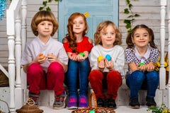 Quattro bei bambini, due ragazzi e due ragazze stanno su una soglia e su una risata di legno immagine stock Quattro bei bambini, due ragazzi e due ragazze stanno su una soglia e su una risata di legno immagine stock