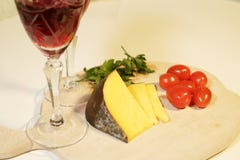 Queijo amarelo cortado e tomates vermelhos pequenos imagens de stock Queijo amarelo cortado e tomates vermelhos pequenos imagens de stock