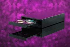 Queimador preto do CD DVD no fundo roxo imagens de stock Queimador preto do CD DVD no fundo roxo imagens de stock