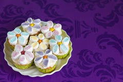 Queques decorados com as flores do creme e do marshmallow da manteiga imagem de stock royalty free Queques decorados com as flores do creme e do marshmallow da manteiga imagem de stock royalty free