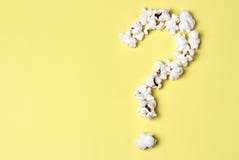 Question mark laid out of popcorn on a yellow background close-up, top view stock photos Question mark laid out of popcorn on a yellow background close-up, top view stock photos