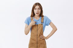 Qui je Belle jeune fille étonnée et stupéfaite dans la salopette brune et le T-shirt bleu se dirigeant au coffre et à regarder photo libre de droits Qui je Belle jeune fille étonnée et stupéfaite dans la salopette brune et le T-shirt bleu se dirigeant au coffre et à regarder photo libre de droits