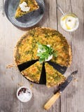 Quiche with arugula, onion, spinach, mozzarella, feta and sauce on rustic background, top view. Homemade, traditional french stock photo Quiche with arugula, onion, spinach, mozzarella, feta and sauce on rustic background, top view. Homemade, traditional french stock photo