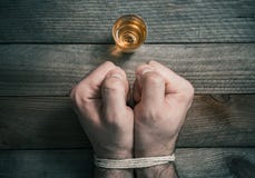 Quit Drinking Alcohol Concept With A Booze Glass In Front Of 2 Tied Stressed Looking Clenched Fists royalty free stock photos Quit Drinking Alcohol Concept With A Booze Glass In Front Of 2 Tied Stressed Looking Clenched Fists royalty free stock photos