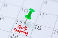 Quit Smoking written on a calendar with a green push pin to rem stock image Quit Smoking written on a calendar with a green push pin to rem stock image