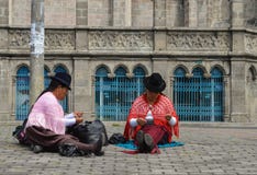 Quito, Ecuador: Two women sewing in the street, practicing their handmade jobs, with traditional Andean clothing