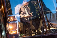 QUÉBEC, CANADA - 21 MAI 2018 : Chauffeur de bus utilisant son smartphone images stock QUÉBEC, CANADA - 21 MAI 2018 : Chauffeur de bus utilisant son smartphone images stock