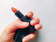 R?ka stawia koralowego lub pomara?czowi ceglani pomadka trendy barwi? na tle bia?ym u?ywaj? dla makeup koralowy pi?knego dla kobi obraz stock R?ka stawia koralowego lub pomara?czowi ceglani pomadka trendy barwi? na tle bia?ym u?ywaj? dla makeup koralowy pi?knego dla kobi obraz stock
