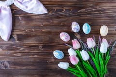 Rabbit ears , tulips and easter eggs on a wooden background stock photos Rabbit ears , tulips and easter eggs on a wooden background stock photos