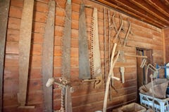 Raccolta di vecchie seghe appese su una parete immagini stock libere da diritti Raccolta di vecchie seghe appese su una parete immagini stock libere da diritti
