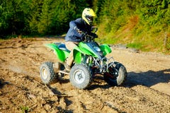 Racer with yellow helmet on green quad enjoying his ride outdoors. royalty free stock photo Racer with yellow helmet on green quad enjoying his ride outdoors. royalty free stock photo