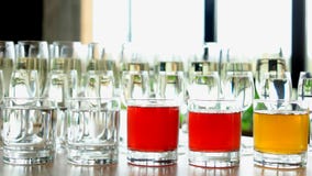 Rader av exponeringsglas med alkoholdrycker på tabellen arkivfoton Rader av exponeringsglas med alkoholdrycker på tabellen arkivfoton