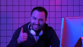 Radosny gamer facet bawić się gra wideo na komputerze i pokazuje kciuk do kamery zdjęcia royalty free Radosny gamer facet bawić się gra wideo na komputerze i pokazuje kciuk do kamery zdjęcia royalty free
