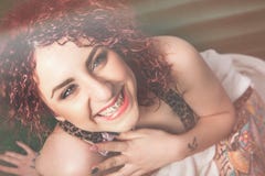 Radość uśmiechać się młodej kobiety z kędzierzawym czerwonym włosy fotografia stock Radość uśmiechać się młodej kobiety z kędzierzawym czerwonym włosy fotografia stock