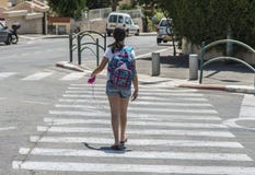 Ragazza adolescente della scuola con uno zaino sul suo indietro e sulle cuffie Fotografia Stock Libera da Diritti Ragazza adolescente della scuola con uno zaino sul suo indietro e sulle cuffie Fotografia Stock Libera da Diritti