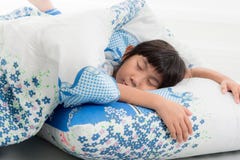 Ragazza asiatica che si trova sotto una coperta nel letto Fotografia Stock Ragazza asiatica che si trova sotto una coperta nel letto Fotografia Stock