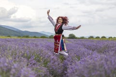 Ragazza bulgara felice in un giacimento della lavanda immagini stock libere da diritti Ragazza bulgara felice in un giacimento della lavanda immagini stock libere da diritti