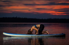 Ragazza che esercita yoga sul paddleboard nel tramonto sul lago scenico Velke Darko fotografia stock libera da diritti Ragazza che esercita yoga sul paddleboard nel tramonto sul lago scenico Velke Darko fotografia stock libera da diritti