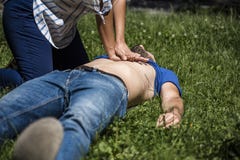 Ragazza che fa rianimazione cardiopolmonare ad un tipo incosciente dopo l'attacco di cuore fotografia stock libera da diritti Ragazza che fa rianimazione cardiopolmonare ad un tipo incosciente dopo l'attacco di cuore fotografia stock libera da diritti