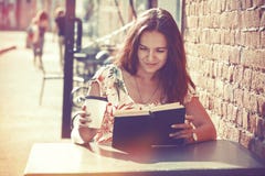 Ragazza con il libro di lettura del caffè fotografia stock Ragazza con il libro di lettura del caffè fotografia stock