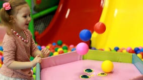 Ragazza del bambino che gioca sul campo da giuoco con i palloni variopinti Giochi del bambino nella stanza per i giochi stock footage Ragazza del bambino che gioca sul campo da giuoco con i palloni variopinti Giochi del bambino nella stanza per i giochi stock footage