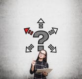 Ragazza del nerd in vestito e punto interrogativo con le frecce fotografie stock libere da diritti Ragazza del nerd in vestito e punto interrogativo con le frecce fotografie stock libere da diritti