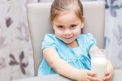 Ragazza del piccolo bambino che beve un latte fotografia stock Ragazza del piccolo bambino che beve un latte fotografia stock