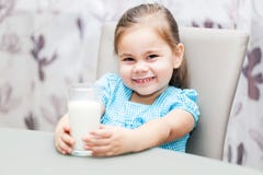 Ragazza del piccolo bambino che beve un latte immagine stock Ragazza del piccolo bambino che beve un latte immagine stock