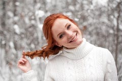 Ragazza dello zenzero in maglione bianco nella neve dicembre della foresta di inverno in parco Tempo di natale fotografia stock Ragazza dello zenzero in maglione bianco nella neve dicembre della foresta di inverno in parco Tempo di natale fotografia stock