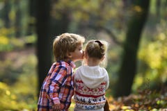 Ragazza di bacio del ragazzino piccola nella sorella di bacio del fratello della foresta di autunno con amore in legno Concetto d Fotografia Stock Ragazza di bacio del ragazzino piccola nella sorella di bacio del fratello della foresta di autunno con amore in legno Concetto d Fotografia Stock
