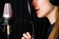 Ragazza di canto in studio di registrazione fotografia stock Ragazza di canto in studio di registrazione fotografia stock