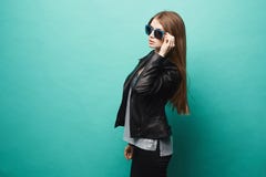 Ragazza di modello alla moda, con forma esile, in bomber ed occhiali da sole, posanti al fondo verde fotografia stock libera da diritti Ragazza di modello alla moda, con forma esile, in bomber ed occhiali da sole, posanti al fondo verde fotografia stock libera da diritti