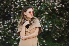 Ragazza di modello bionda alla moda e sensuale in cappotto senza maniche ed in occhiali da sole alla moda fotografie stock libere da diritti Ragazza di modello bionda alla moda e sensuale in cappotto senza maniche ed in occhiali da sole alla moda fotografie stock libere da diritti